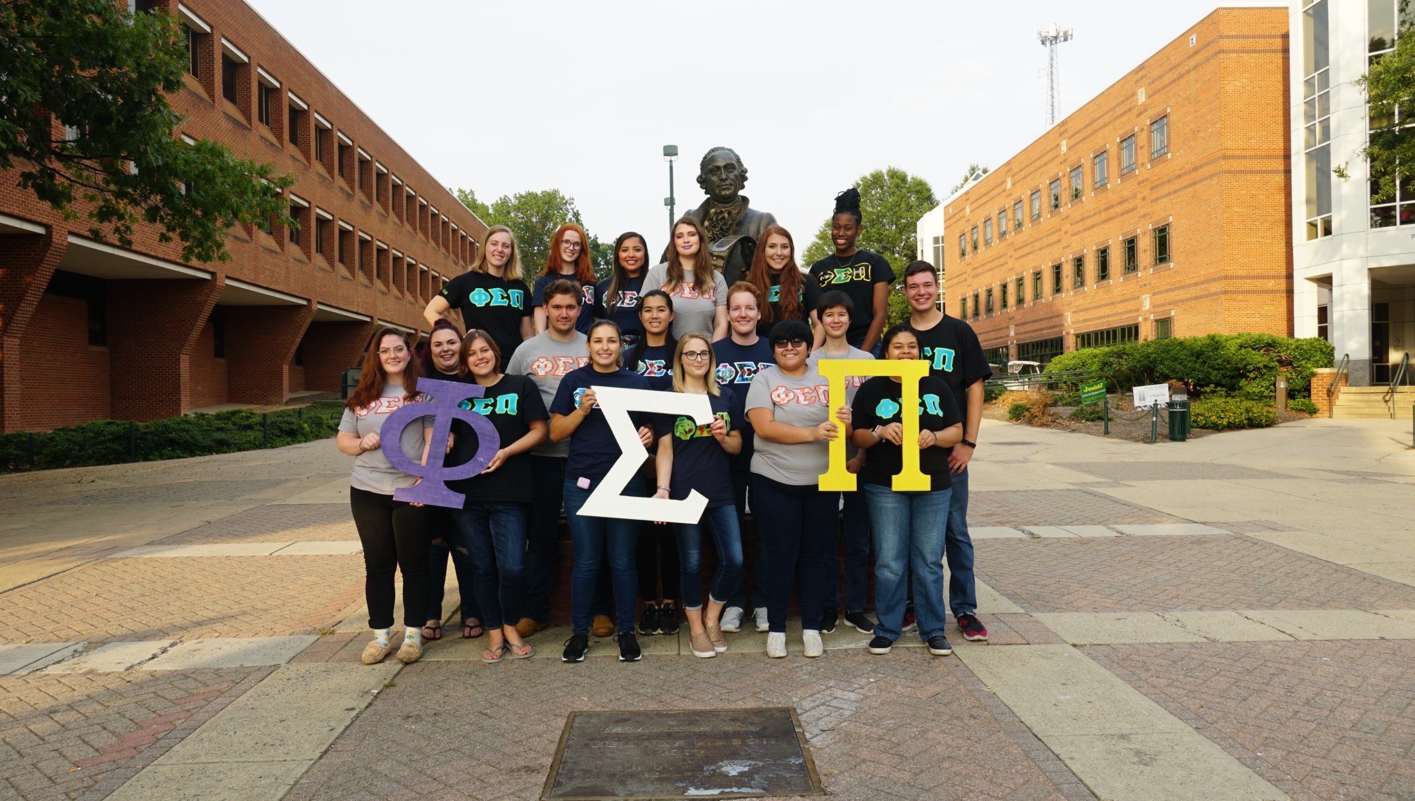 Members of the Zeta Delta Chapter posing in front of the Mason statue.