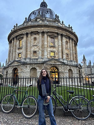 Christina Gizzi standing in front of a baroque style building with bicycles