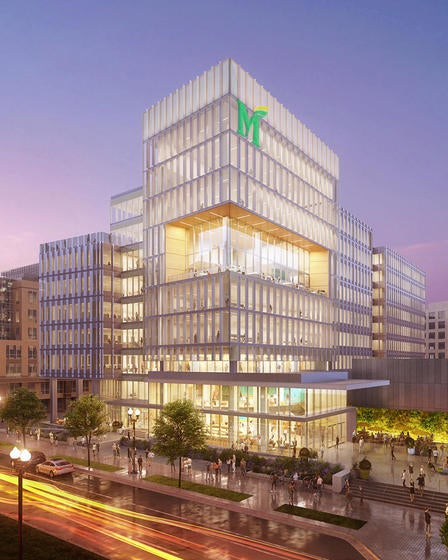 A mockup of the future Fuse building at dusk, with people walking in and around it.