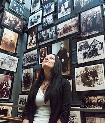Laura Mahan surrounded by pictures of Holocaust victims