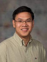 ThanhVu Nguyen wears a beige shirt and glasses in his faculty profile for the Computer Science Department at Mason.