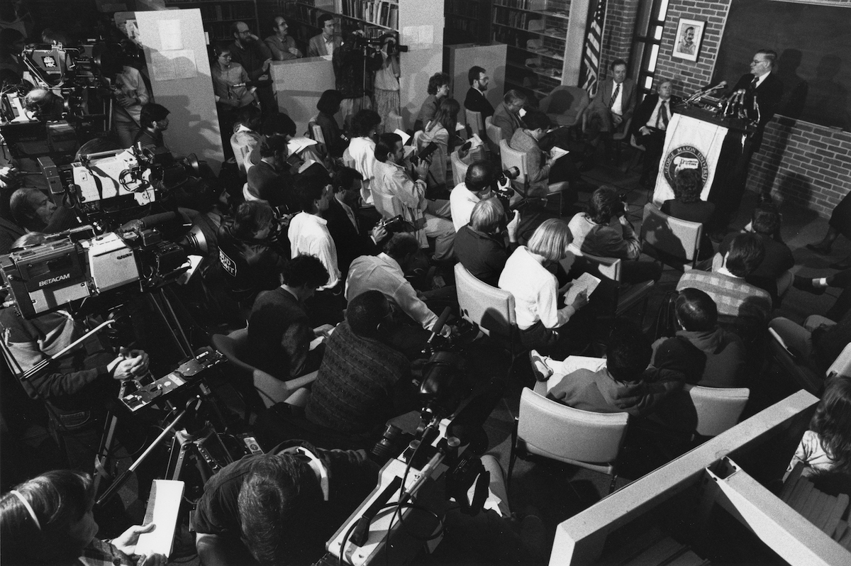 black and white photo of reporters and camera people at a press conference