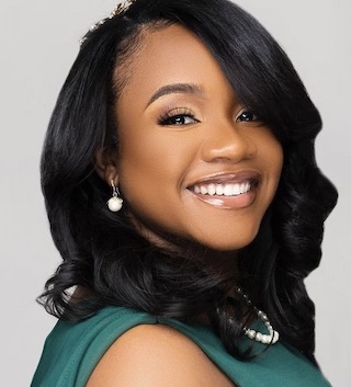 A headshot of law student Bianca Hancock-Siggers. She is smiling at the camera and wearing a green sleeveless dress.
