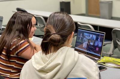 Dos estudiantes en una reunión virtual en una computadora portátil