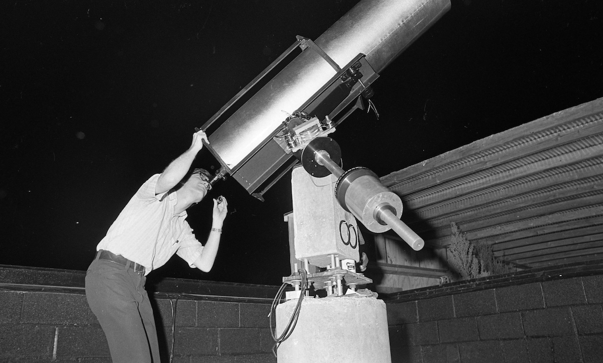 guy looking through telescope