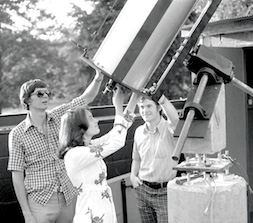 three people with a telescope