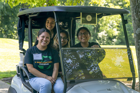 four girls in a golf cart