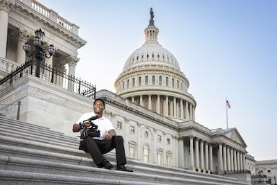 man sitting on the steps of the us capitol