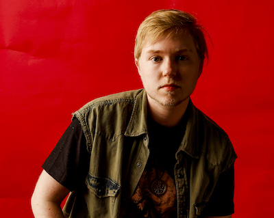 young man in front of a red background