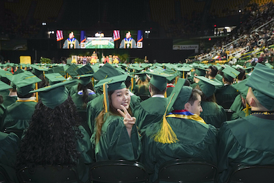 student waving during Commencement