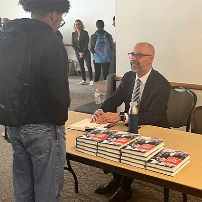 Dr. Brian P. Jones signs copies of his book after the lecture. Photo by Shayla Brown.
