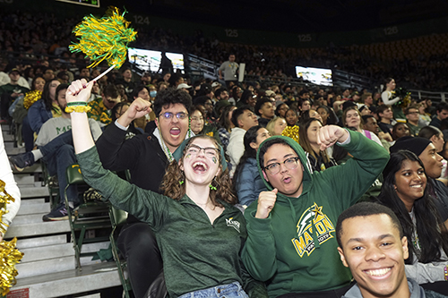 Students cheer during men's basketball game at Homecoming 2023