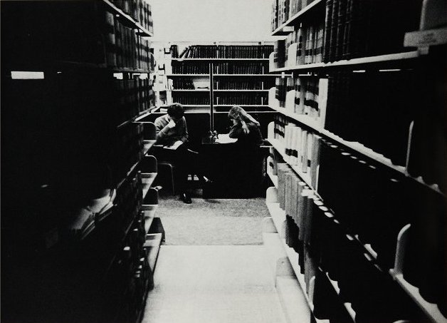 A male and female student studying in the law school library. 