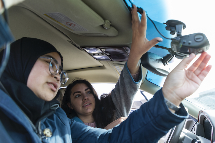 Students installing an air pollution monitor in a car.