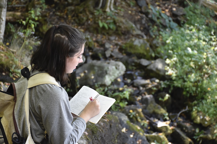 A student at the Smithsonian-Mason School of Conservation records observations in the field