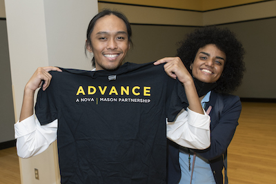 students hold up an ADVANCE shirt at event