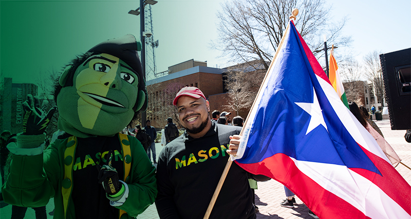 A Mason student poses with the Patriot, Mason's mascot, during International Week