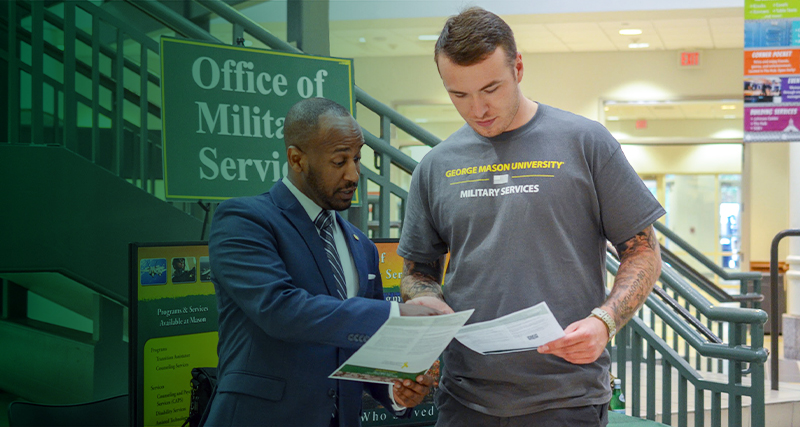 A student volunteering with the Office of Military Services works with an employee in the Johnson Center.