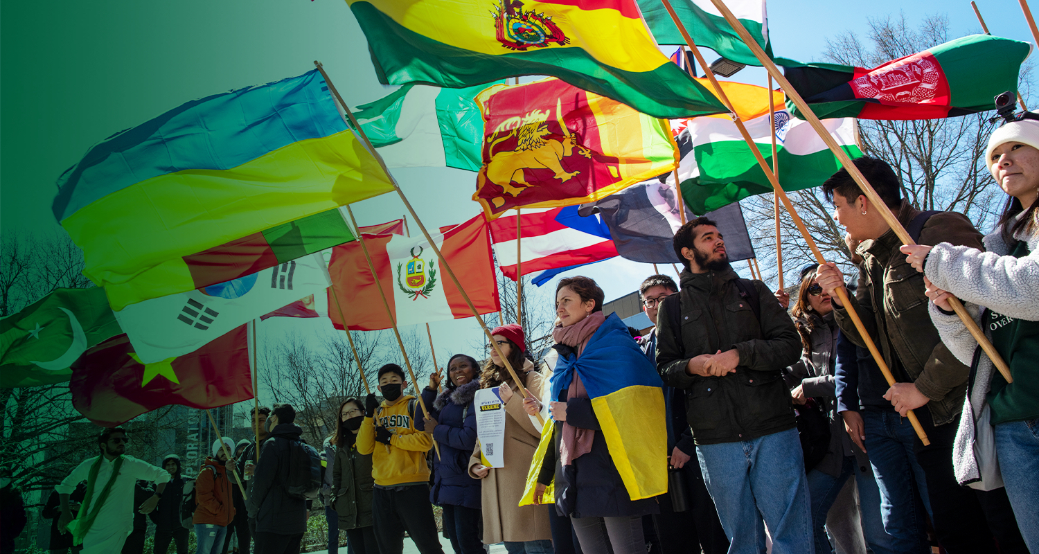 A group of international students stand with their nations' flags during an International Week celebration.