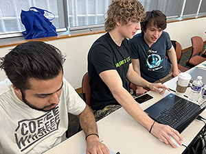 students at a table during cybersecurity competition