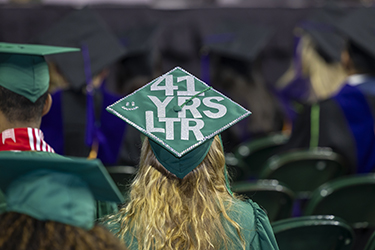 A graduate's cap reads "41 Yrs Ltr", shorthand for "41 years later"