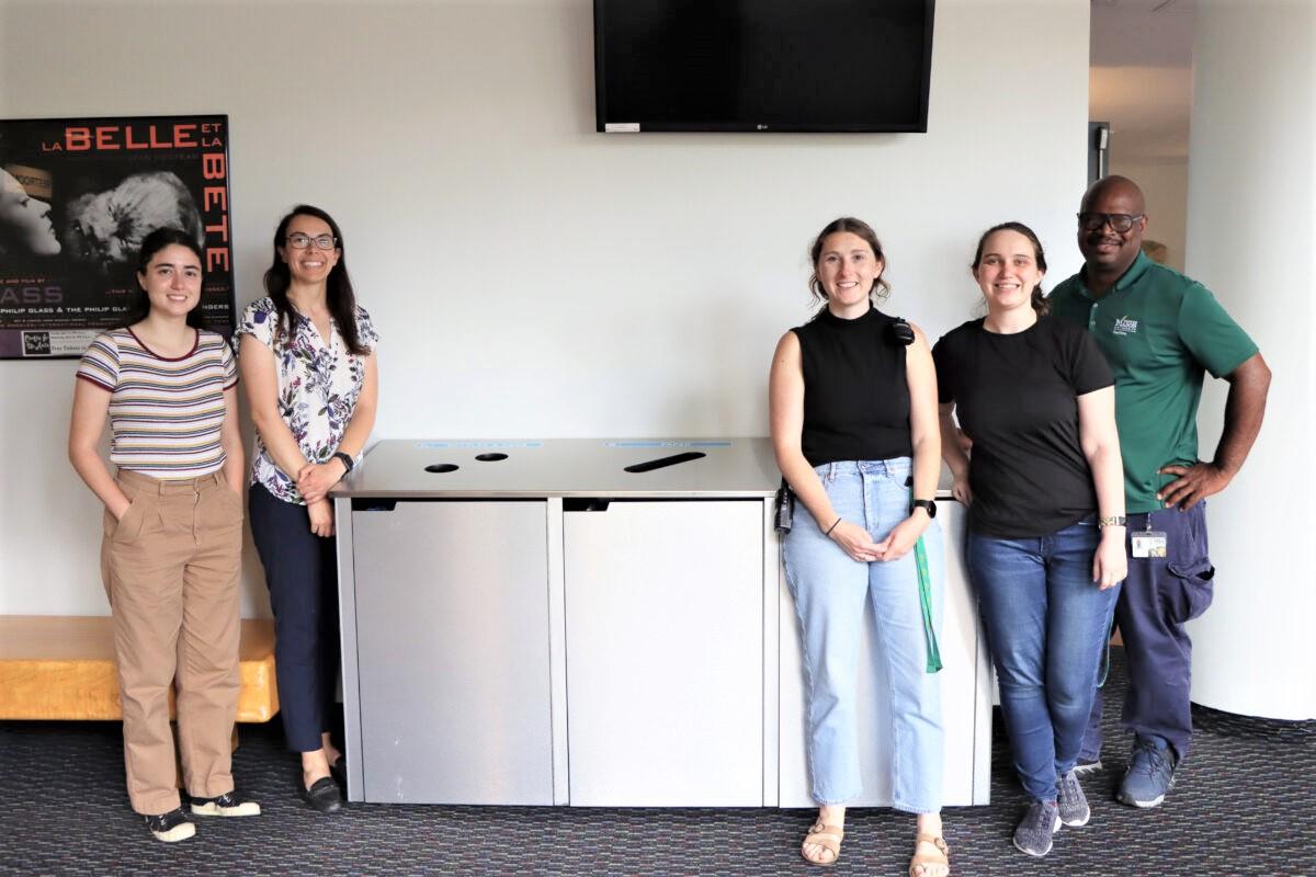 Photo of Mason staff members next to the newly installed recycling bins in the Center for the Arts lobby