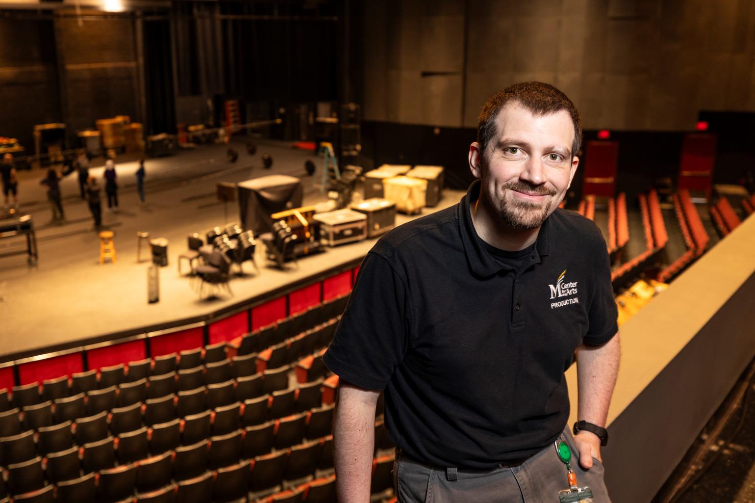 Will Gautney stands on the balcony of the Center for the Arts with the stage below 