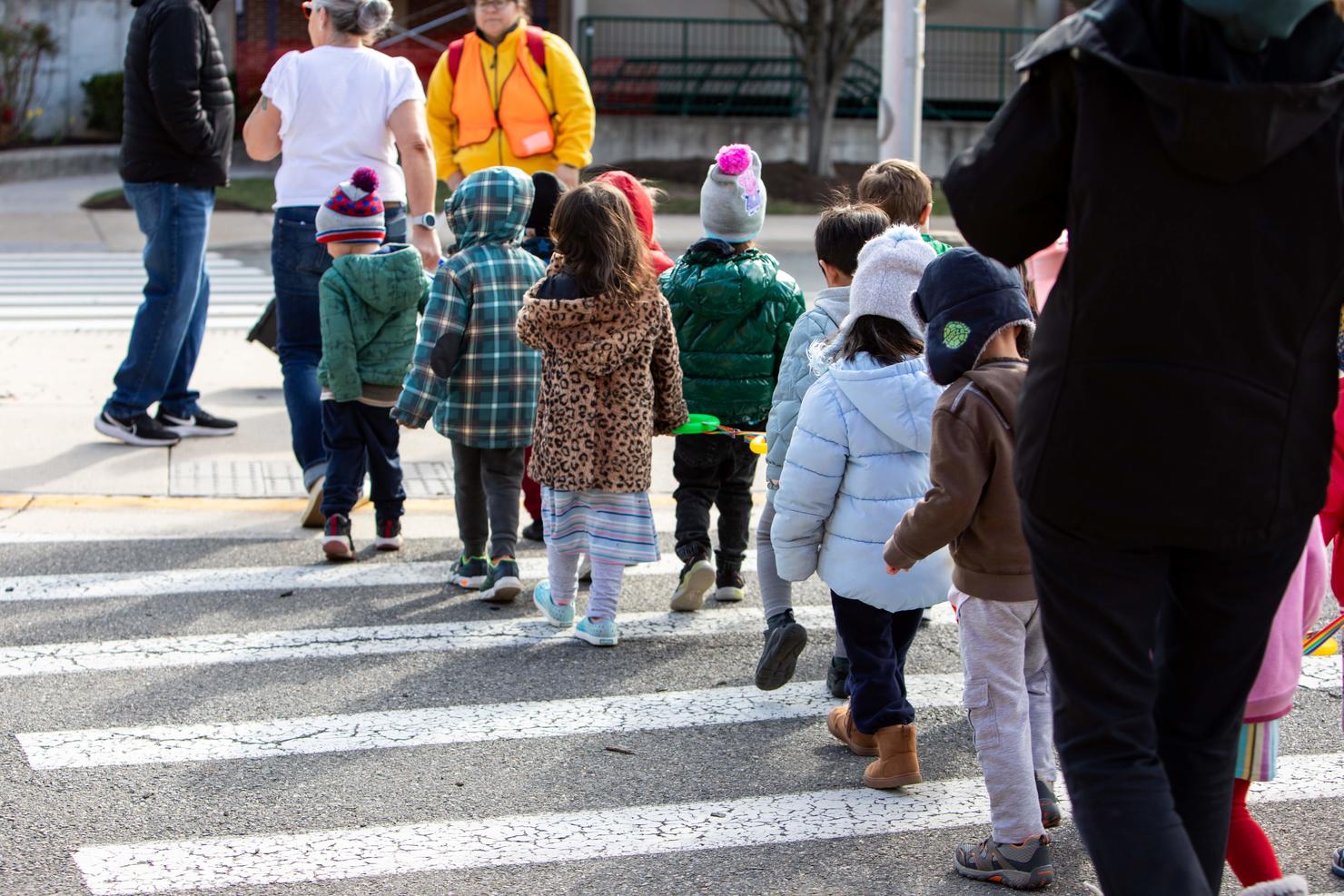 Children walk in a line toward the Mason Shuttle stop