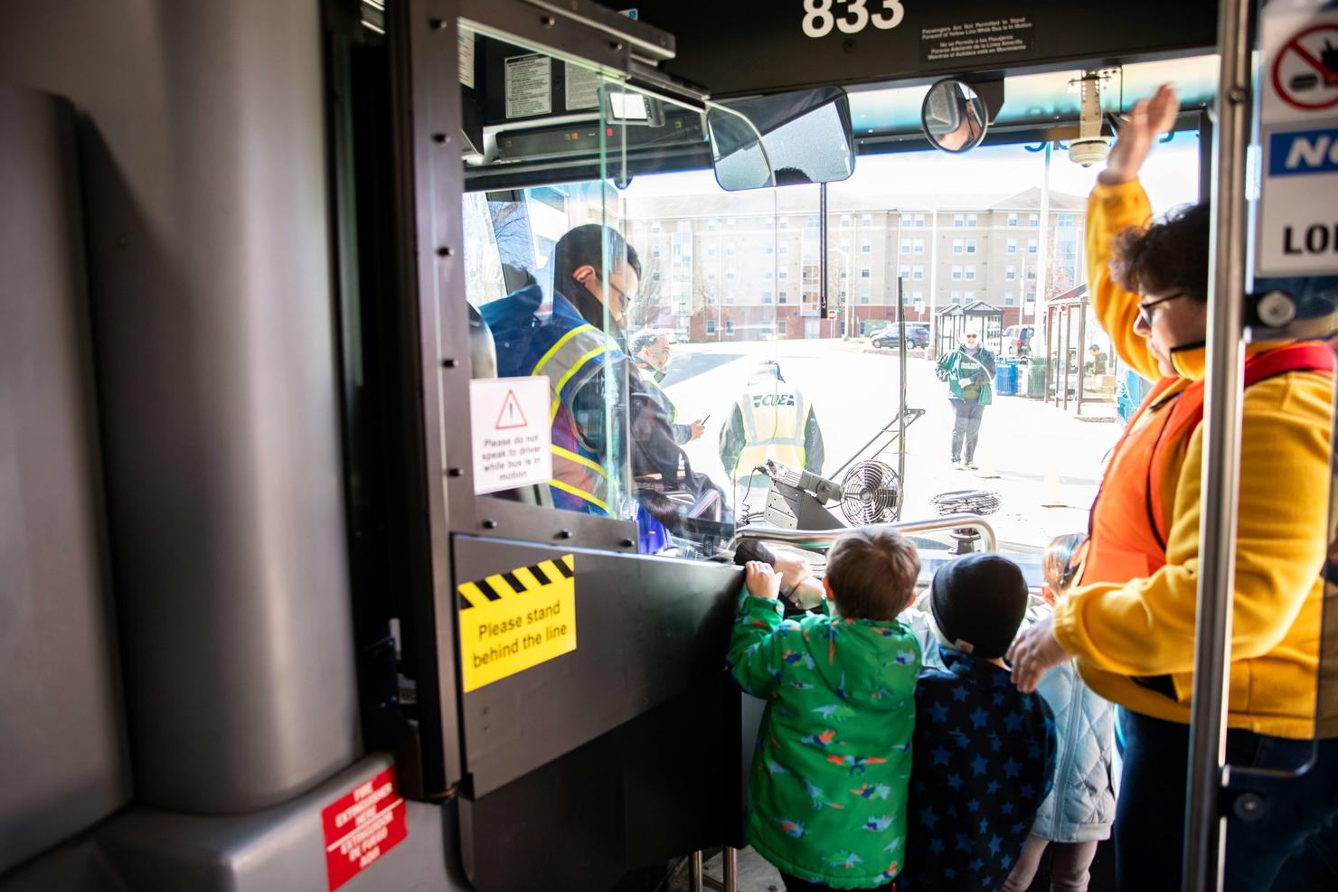 Children visit with a bus driver and give an appreciation gift bag