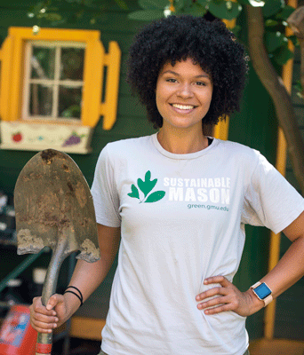 Mason student wearing sustainability T shirt holding shovel