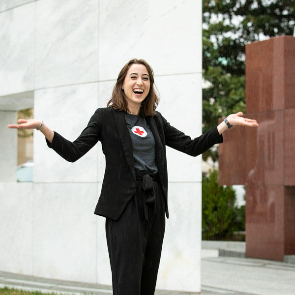 Mason student Jennifer Lyon poses joyfully in front of the headquarters of the American Red Cross, where she was able to complete an internship
