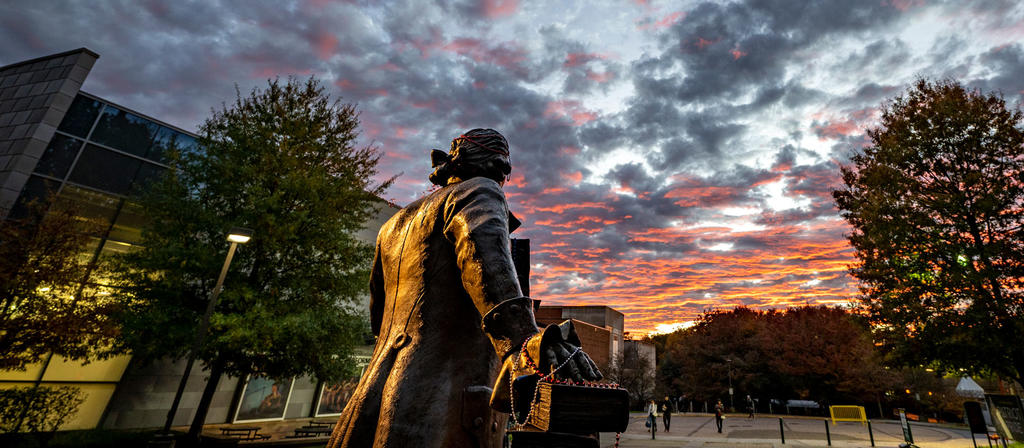 Rear view of George Mason statue on Mason Fairfax Campus at sunset