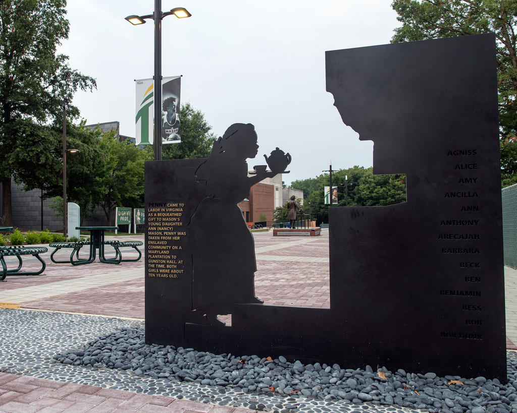 The statue of George Mason is visible through the Enslaved People of George Mason Memorial