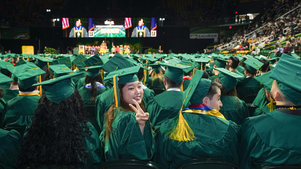 Graduates wave to family members during Winter Commencement 2022 at EagleBank Arena.