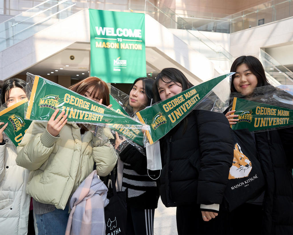 Mason Korea students pose with holding banners that read George Mason University