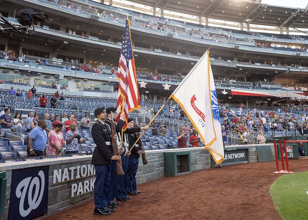 The Patriot Battalion Color Guard presents the US colors during Mason Night at Nationals Park.