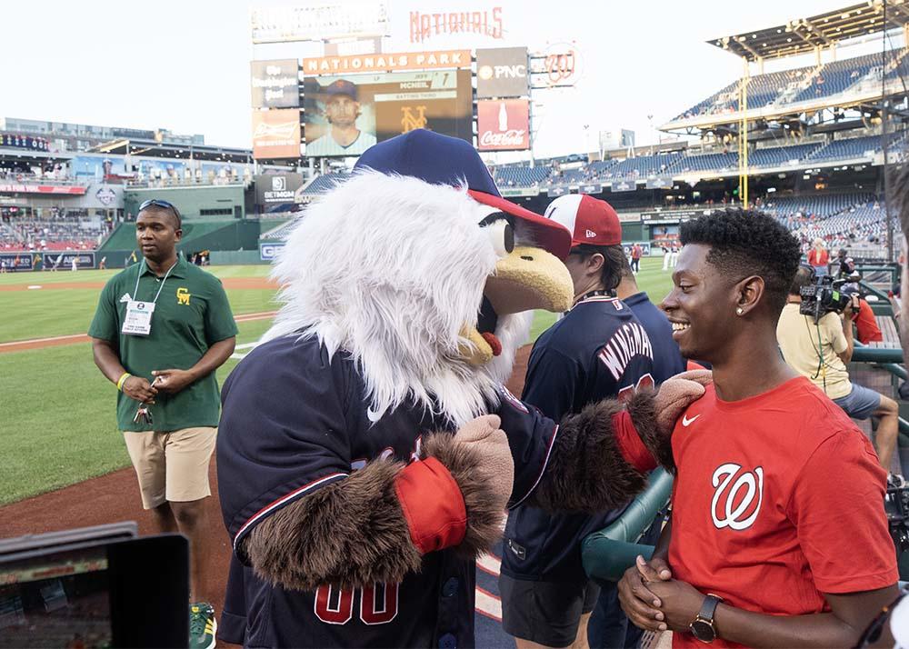 Alumnus Brandon Showell laughs with the National's mascot, the Eagle.