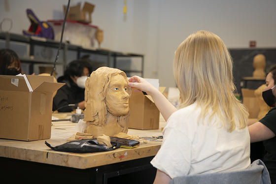 A student works on a clay self-portrait in the Forensic Sculpture class