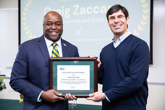 Craig Zaccaro accepts the framed award from President Gregory Washington