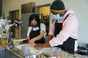 Image of two Mason community members cooking healthy recipes in the Nutrition kitchen