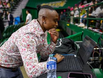 Faith Brown looking at data on a laptop in EagleBank Arena