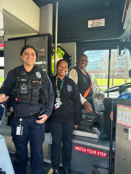 Two Mason Police officers pose and smile with a bus driver on a bus