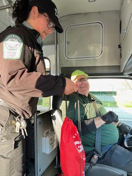 Mason Police officer gives an appreciation bag to a transit driver on a bus